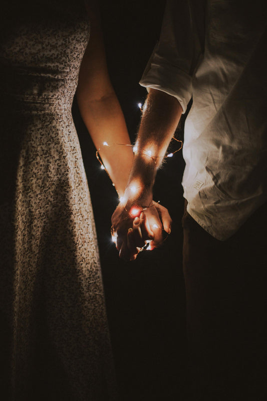 Couple holding hands with fairy lights 